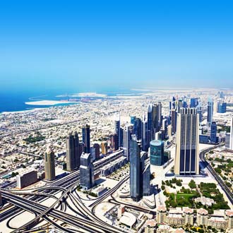 Blik van boven op wolkenkrabbers, wegen en zee Dubai
